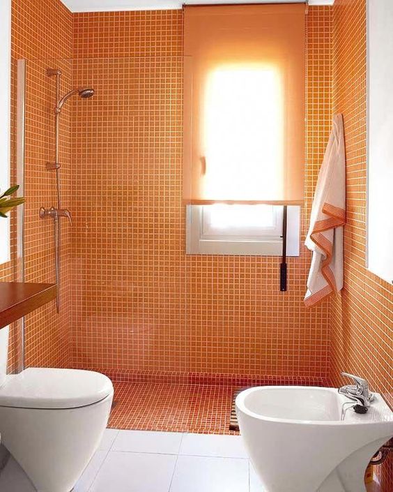 a colorful orange and white bathroom looks bright and lively and will raise up the spirits every time you enter