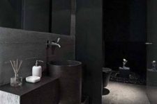 a contemporary black bathroom with a floating vanity and a sink, a black shower space and a toilet, a large mirror