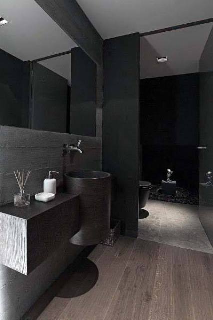 a contemporary black bathroom with a floating vanity and a sink, a black shower space and a toilet, a large mirror