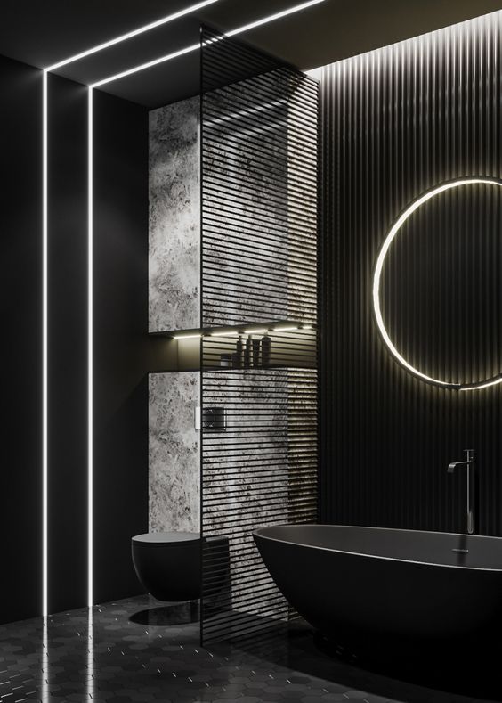 a contemporary black bathroom with an oval tub, a lit up mirror, a toilet, an accent wall and some built-in lights