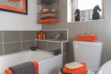 a grey, orange and white bathroom with all the colors mixed up stylishly and some catchy decor elements here and there