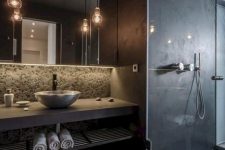 a matta black contemporary bathroom with a shower, pendant lamps, a concrete vanity and a vessel sink