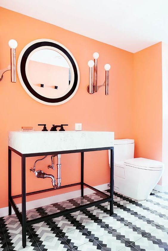a monochromatic black and white bathroom with an accent light orange wall that makes a statement in the space