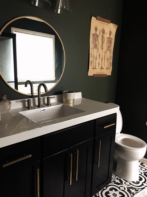 a stylish and moody bathroom with matte black walls, a black vanity, a white stone countertop and catchy artworks