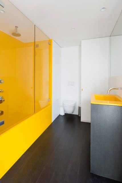 an ultra minimalist bathroom with a yellow shower space and a vanity with a yellow sink, white walls and a toilet