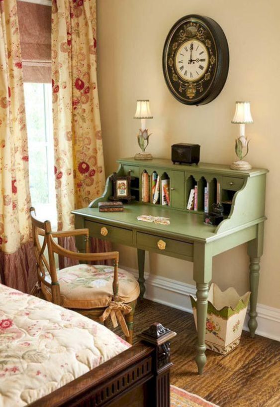 a cozy vintage working nook with a green bureau desk, a floral chair and a floral trash can plus a vintage black clock