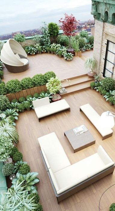 a modern neutral terracr with some pretty outdoor furniture, potted greenery and plants and a single tree plus cool views