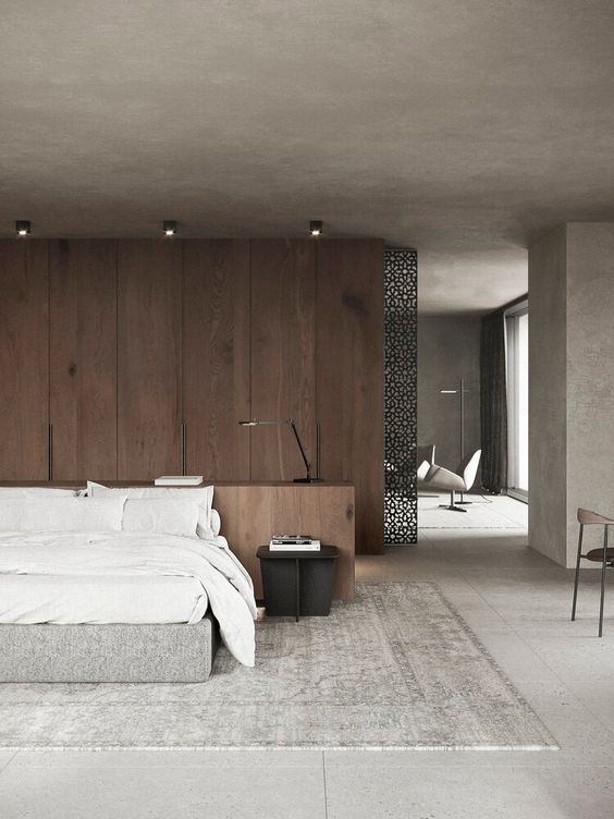 a modern zen bedroom with a wooden accent wall, an upholstered bed with white bedding, a black metal nightstand and lights