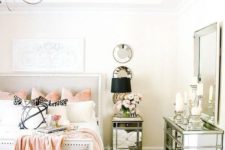 a stylish glam bedroom with an upholstered bed, mirror furniture, lamps and candles plus faux fur rugs