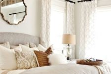 a vintage glam bedroom with a crystal chandelier, a mirror, printed textilesand lamps and candles