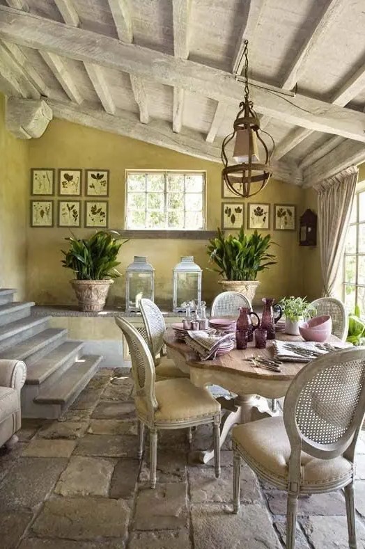a Provence dining space with yellow walls and a whitewashed ceiling, a refined vintage table and vintage chairs, a gallery wall