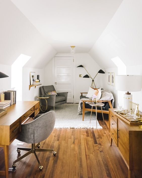 a chic attic home office with stained modern furniture, upholstered grey chairs, cool matching lamps is a very cozy space