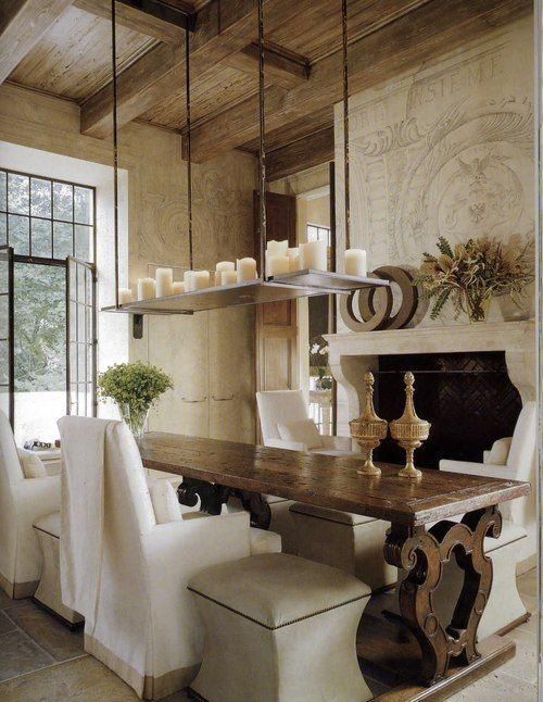 a refined French country dining room with a non-working fireplace, a dark-stained table and neutral chairs and stools