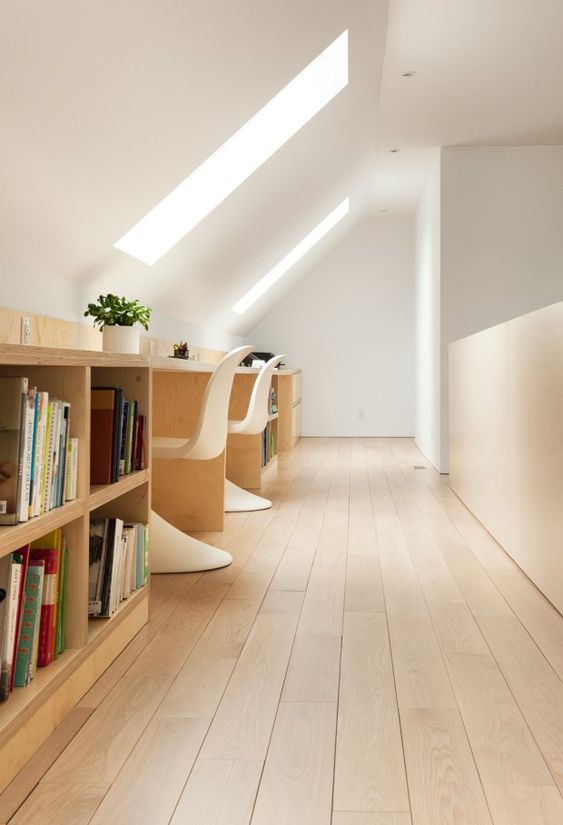 a shared attic home office in minimalist style, with skylights, a long shared desk with storage, white sculptural chairs is clean and airy