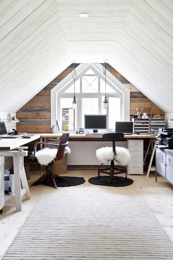 a shared rustic attic home office with a reclaimed wood accent wall, a corner desk, stained chairs, faux fur and pendant lamps
