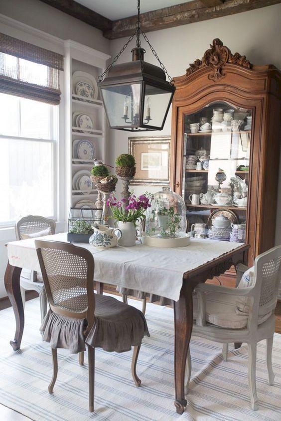a vintage French dining space with a stained buffet, wall-mounted shelves, a vintage dining table and vintage chairs