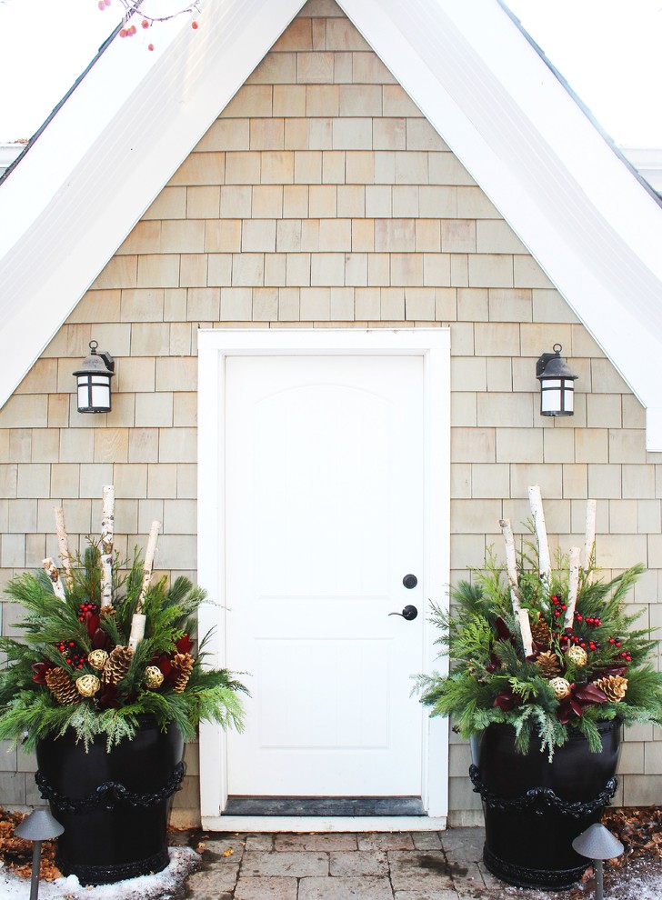 Two large planters filled with evergreen trimmings, pinecones, logs and berries are a perfect solution to frame your front door.