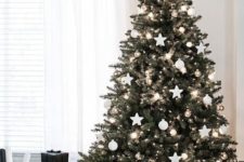 a Christmas tree with lights, balls and star ornaments and metallic ones for an elegant Scandinavian tree