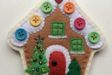 a colorful felt Christmas ornament with bright beads showing off a house with tiny Christmas trees is a lovely idea