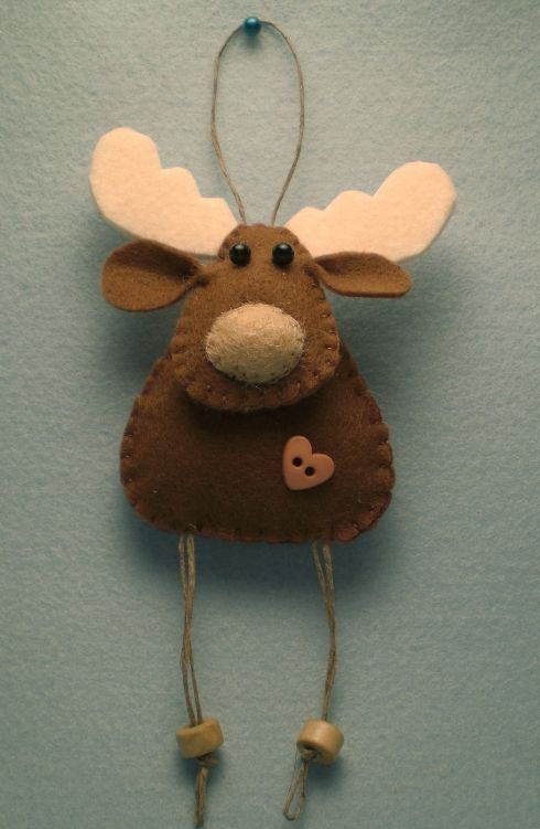 a deer Christmas ornament of felt with a heart button and mini buttons hanging is a very pretty and cozy idea to rock