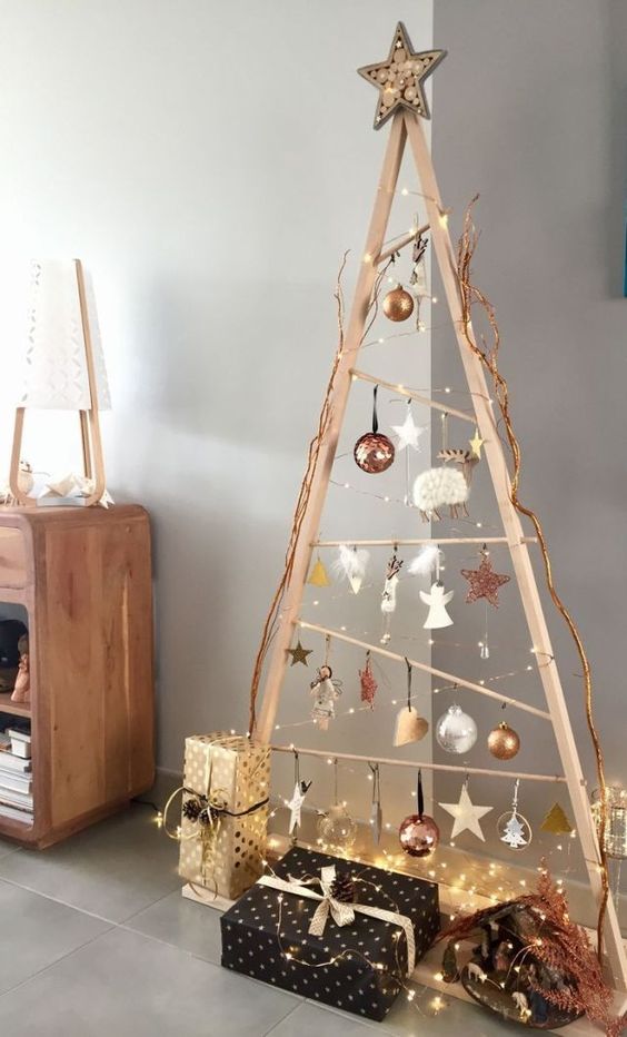 a modern framed Scandinavian Christmas tree with lights, white and copper ornaments and glam gift boxes