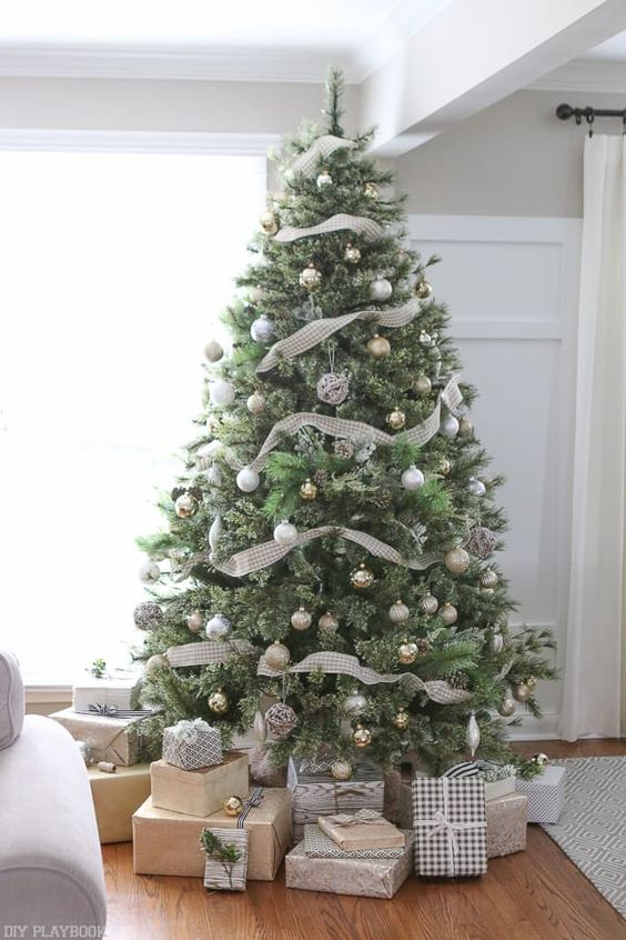a neutral Christmas tree with lots of metallic ornaments and plaid ribbons looks very calm and cute