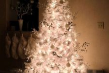 a white Christmas tree with lights, berries and white ornaments plus a shiny star for a frozen look in your space