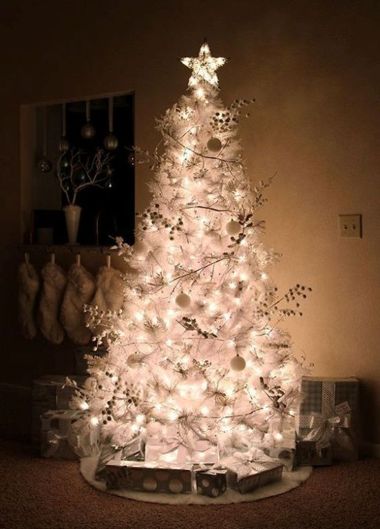 a white Christmas tree with lights, berries and white ornaments plus a shiny star for a frozen look in your space