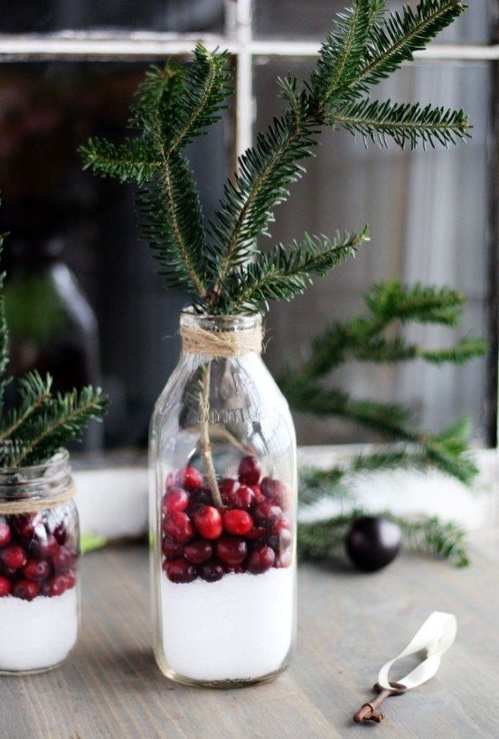 bottles with evergreens, cranberries and faux snow can be used as Scandinavian centerpieces