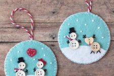 bright felt Christmas ornaments of blue and white felt, with buttons showing off fun Christmas scenes are amazing
