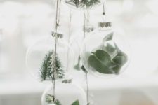 clear glass ornaments with greenery and evergreens hung in a cluster for a natural feel