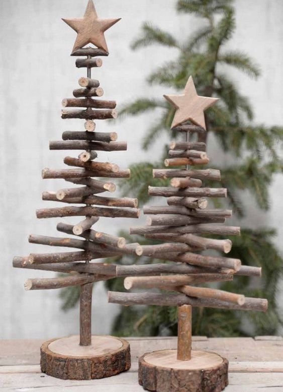 Christmas trees made of sticks with wooden stars placed on wooden slices for a rustic touch