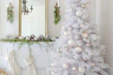 a fabulous Christmas space in white, with a white Christmas tree with pearl, white and pink ornaments and beads, snowy pinecones and white stockings