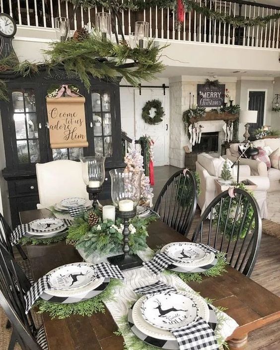 a farmhouse Christmas table with black and white plaid napkins, evergreens and deer printed plates plus candles in candleholders