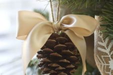 a rustic Christmas ornament of a pinecone with a large silk bow is an easy DIY