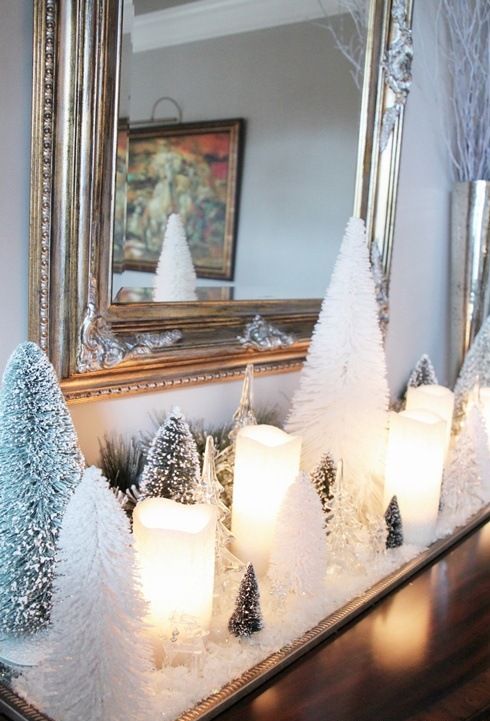 a tray with faux snow, pillar candles and flocked and just white bottle brush Christmas trees for elegant holiday decor