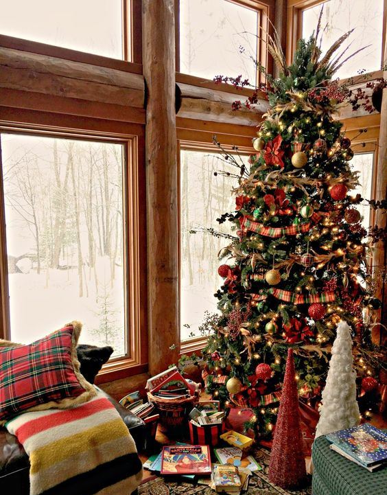 a vintage Christmas tree with lights, red, gold and green ornaments, twigs, berries and herbs