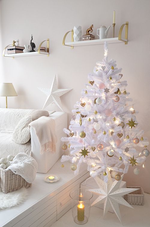 a white lit up Christmas tree with pink, gold and white ornaments, a large star is ideal for this glam white space