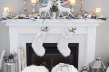 beautiful vintage Christmas decor in white, with deer, faux fur stockings, faux fur stools, candle lanterns, evergreens and gift boxes in white and silver