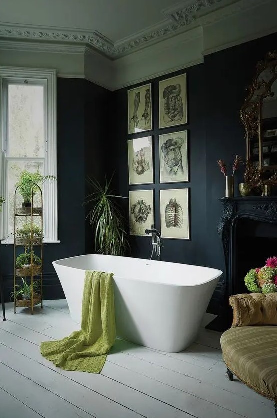 a Victorian Gothic bathroom with black walls and molding on the ceiling, a refined black fireplace, a modern tub, a grid gallery wall and lots of potted plants