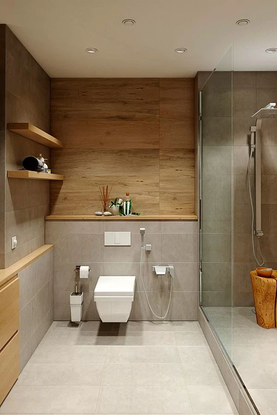 a chic minimalist bathroom clad with grey tiles and wood, with a shower space and a tree stump, open shelves for storage