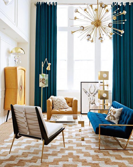 a colorful mid-century modern space with a sunburst chandelier, navy and yeloow items, metallic touches and prints