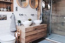 a lovely contemporary bathroom with a wood clad shower space, a wooden vanity, mirrors in wooden frames, laminate floor, a niche clad with wood