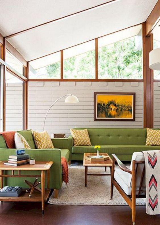 a mid-century modern room with green furniture, neon green and rust textiles, light-colroed wood and skylights