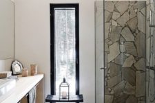 a minimalist bathroom with a floor and a shower space clad with stone plus a sleek modern vanity