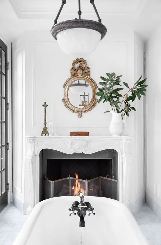 a vintage fireplace in the bathroom is working, there's a metal screen and burning firewood