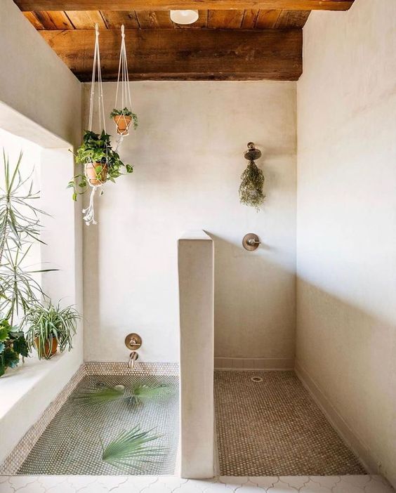 a Moroccan-inspired bathroom with greenery in planters suspended over the tub and on the windowsill
