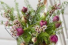 a basket filled with eggs and with greenery and pink blooms on top is a cozy Easter centerpiece