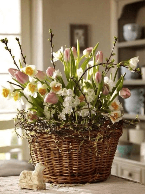 a basket with vines, pink tulips and daffodils, pussy willow is a cool Easter-inspired arrangement