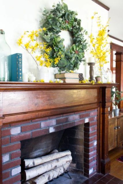 a bright spring mantel with a succulent and greenery wreath, bright yellow blooms and some candles